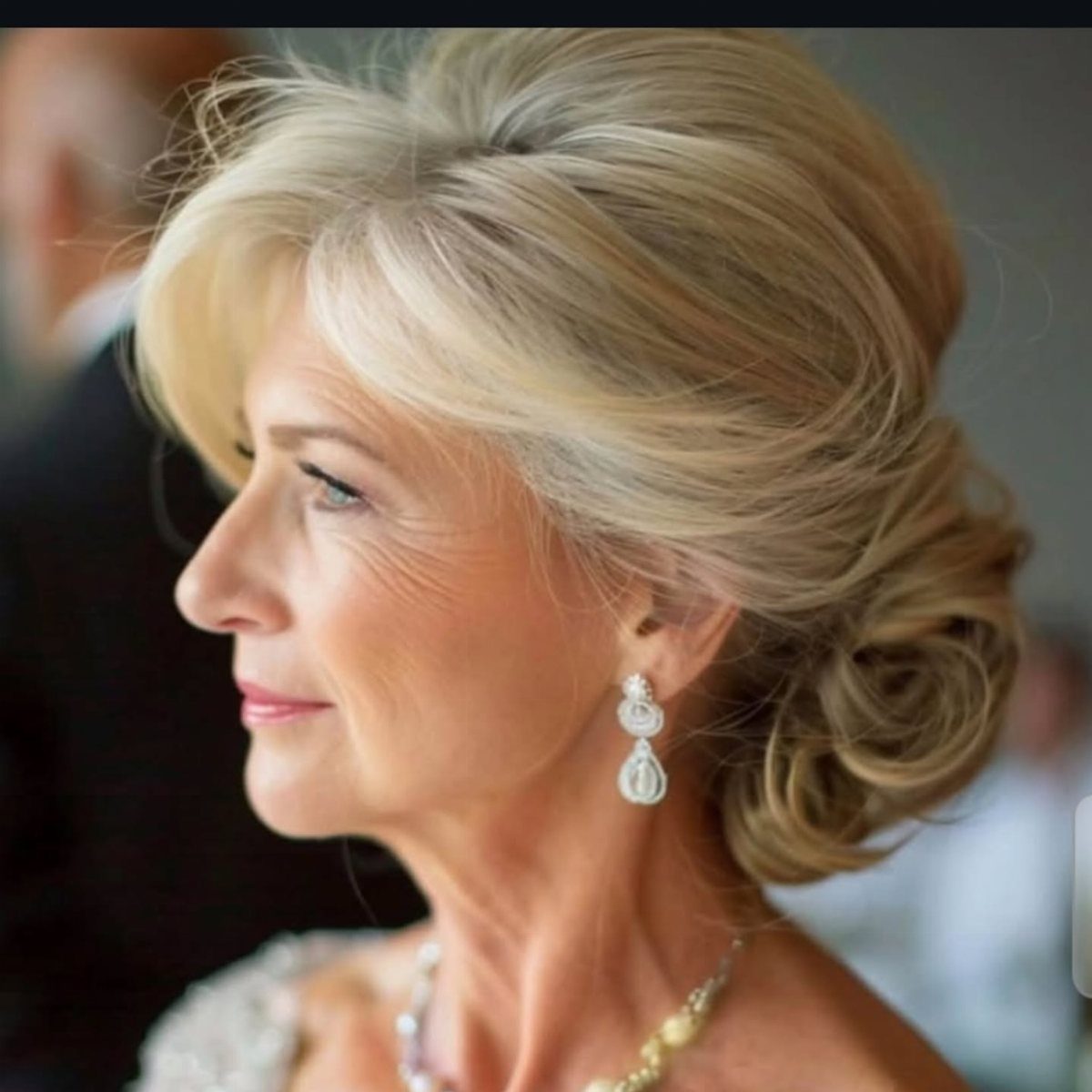Blonde woman with a softly twisted updo and loose face-framing strands