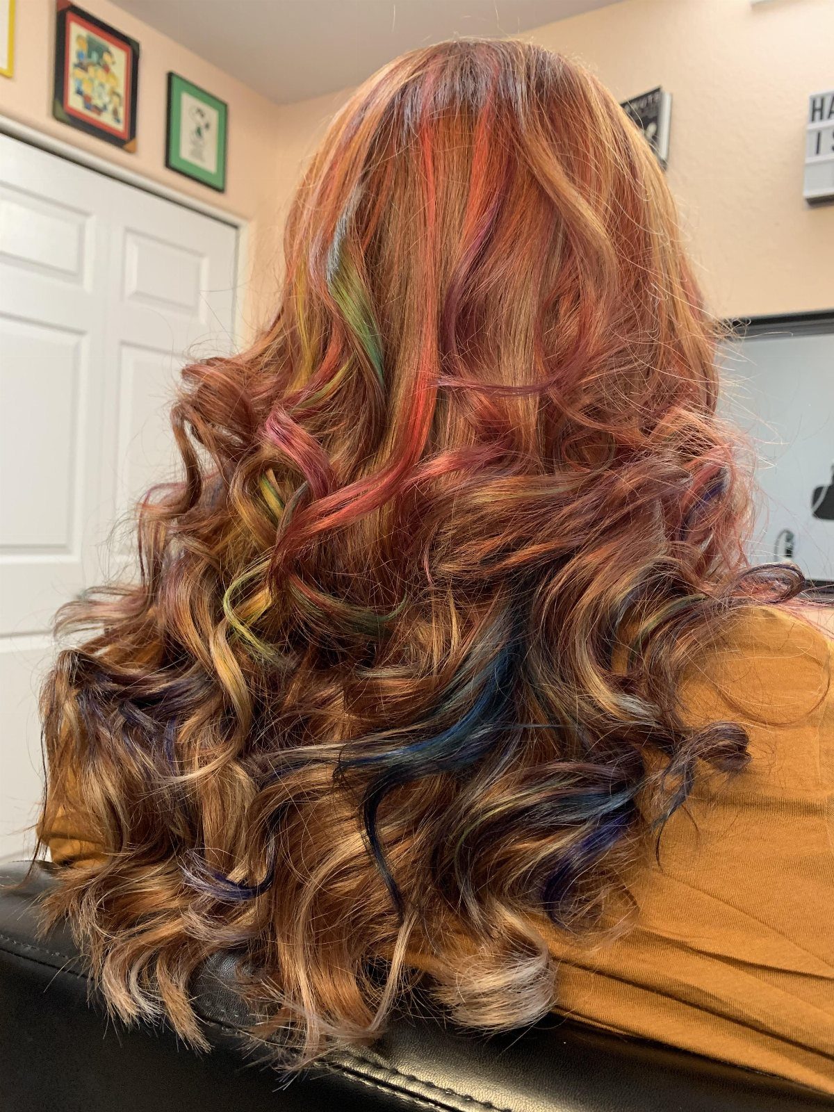 Long curled hair with teal, pink, purple, green, and gold streaks