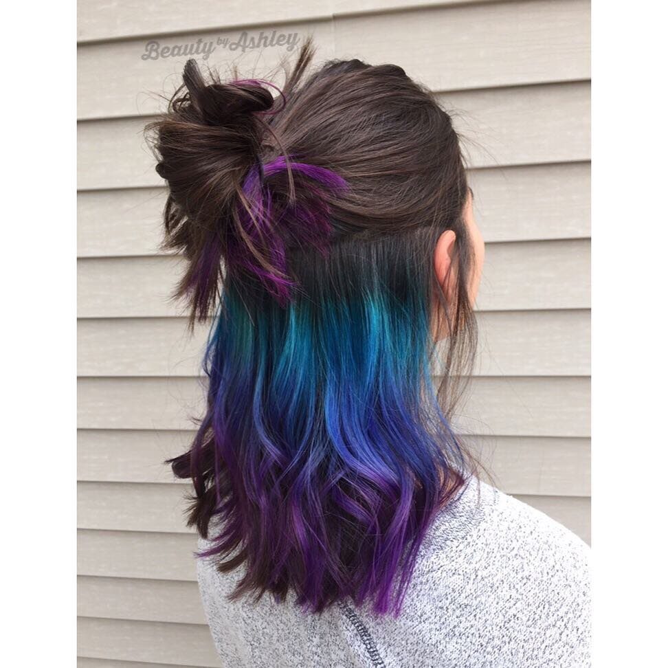 Dark hair with wavy teal, blue, and purple lengths pinned partly up