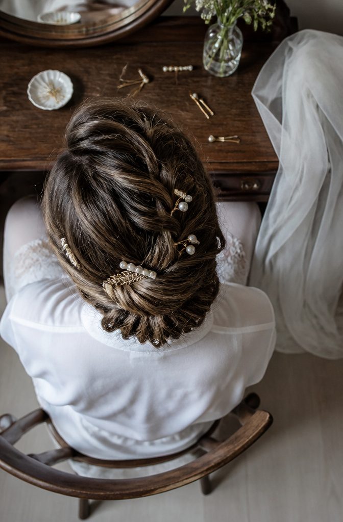 Pearl pins and combs arranged along a braided hairstyle