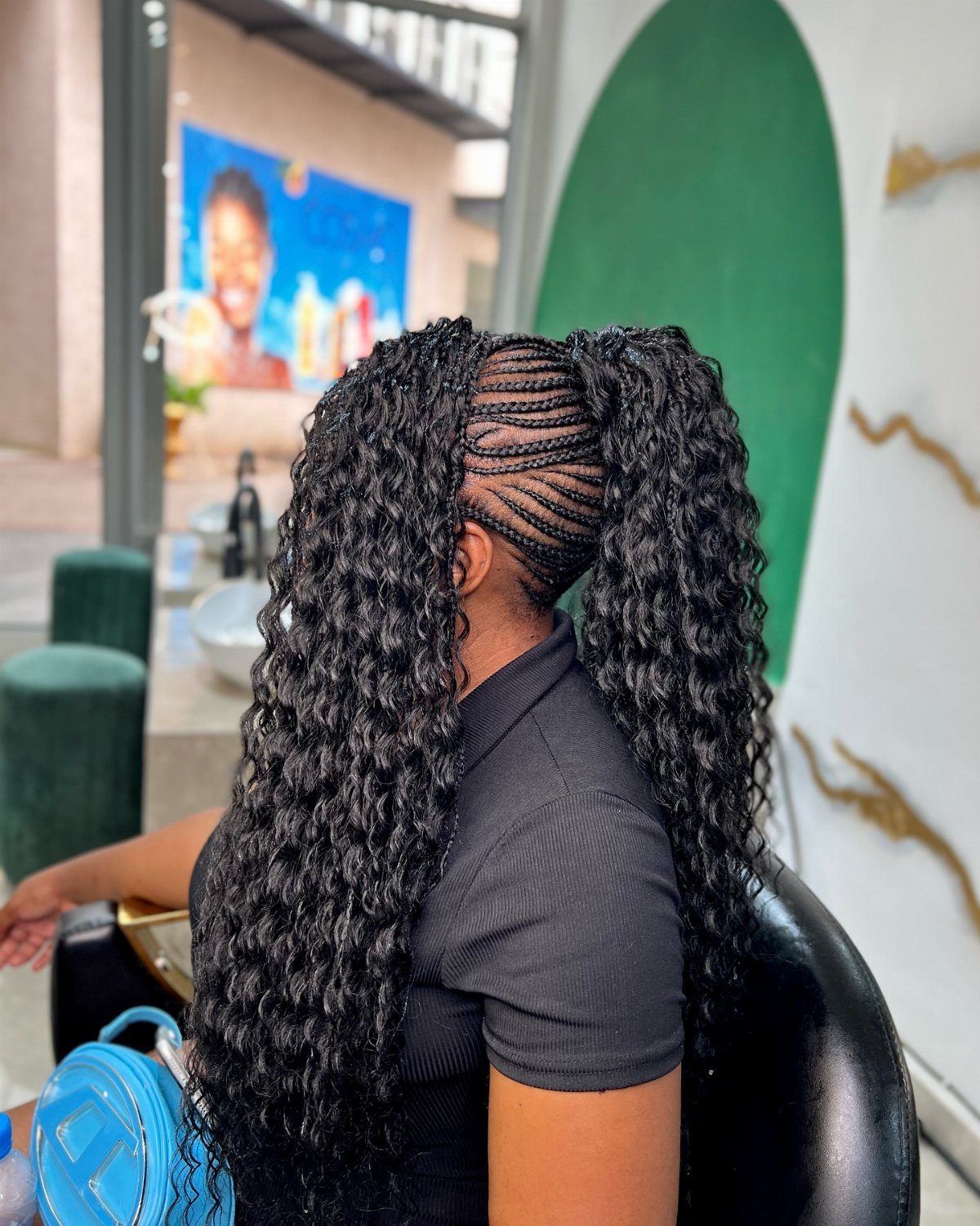 Long curly hair gathered into two sections with narrow braids along one side