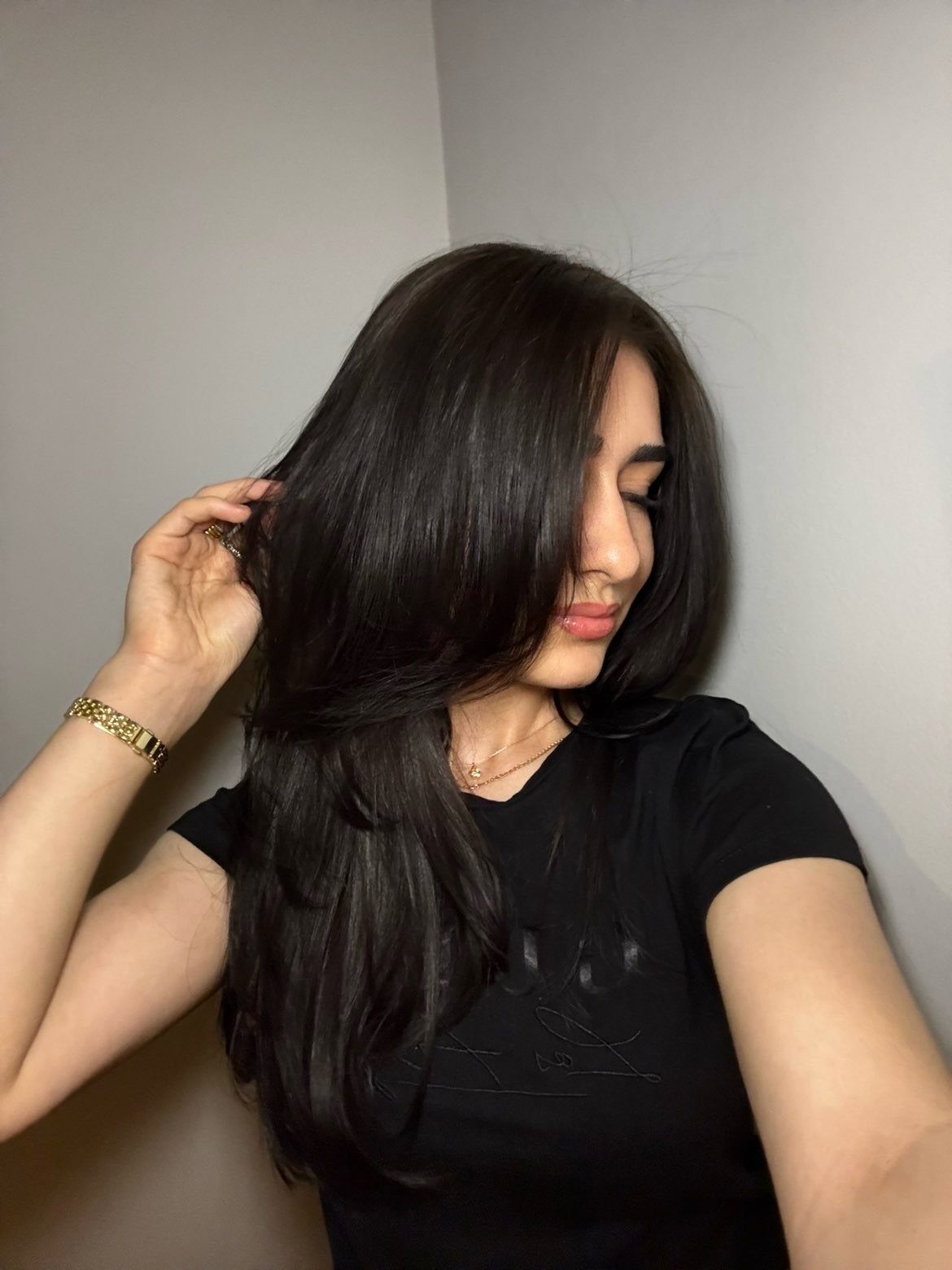 Woman with glossy dark hair in a deep side part covering one side of her face