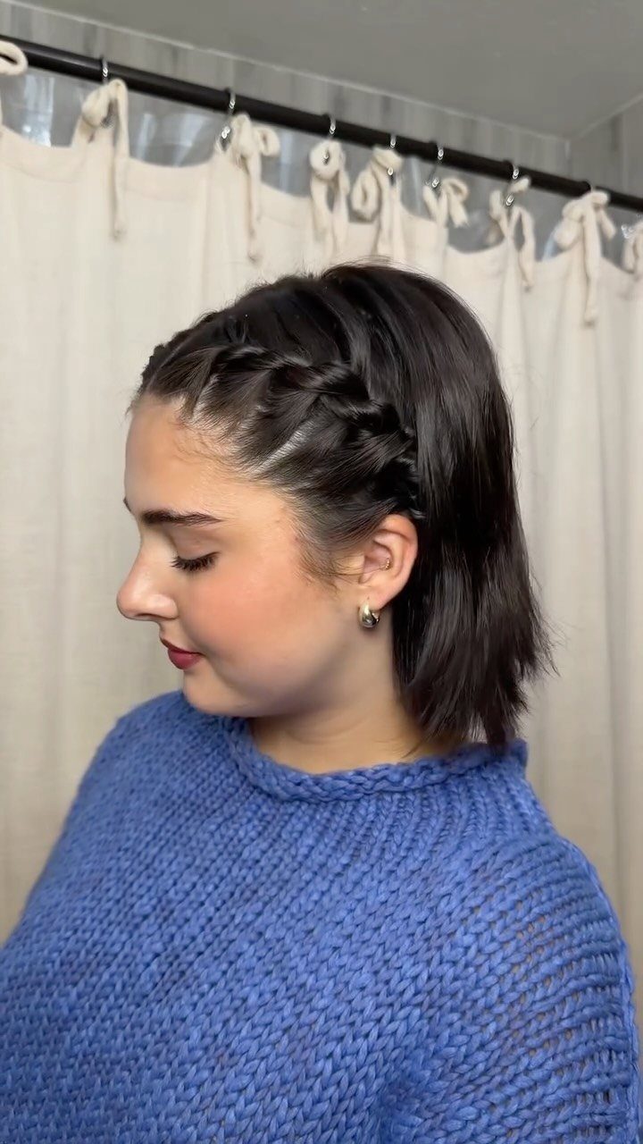 Woman showing a side-braided half-up hairstyle with dark hair left down