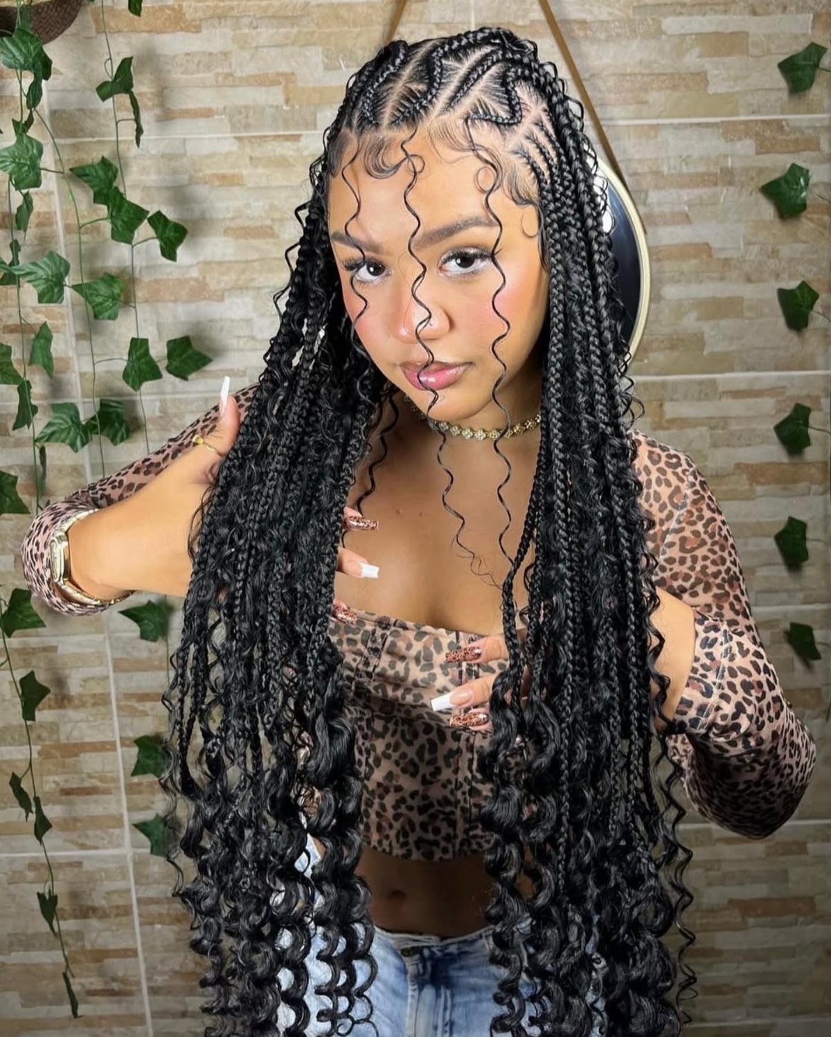 Woman showing long black braids with curled ends and styled baby hairs