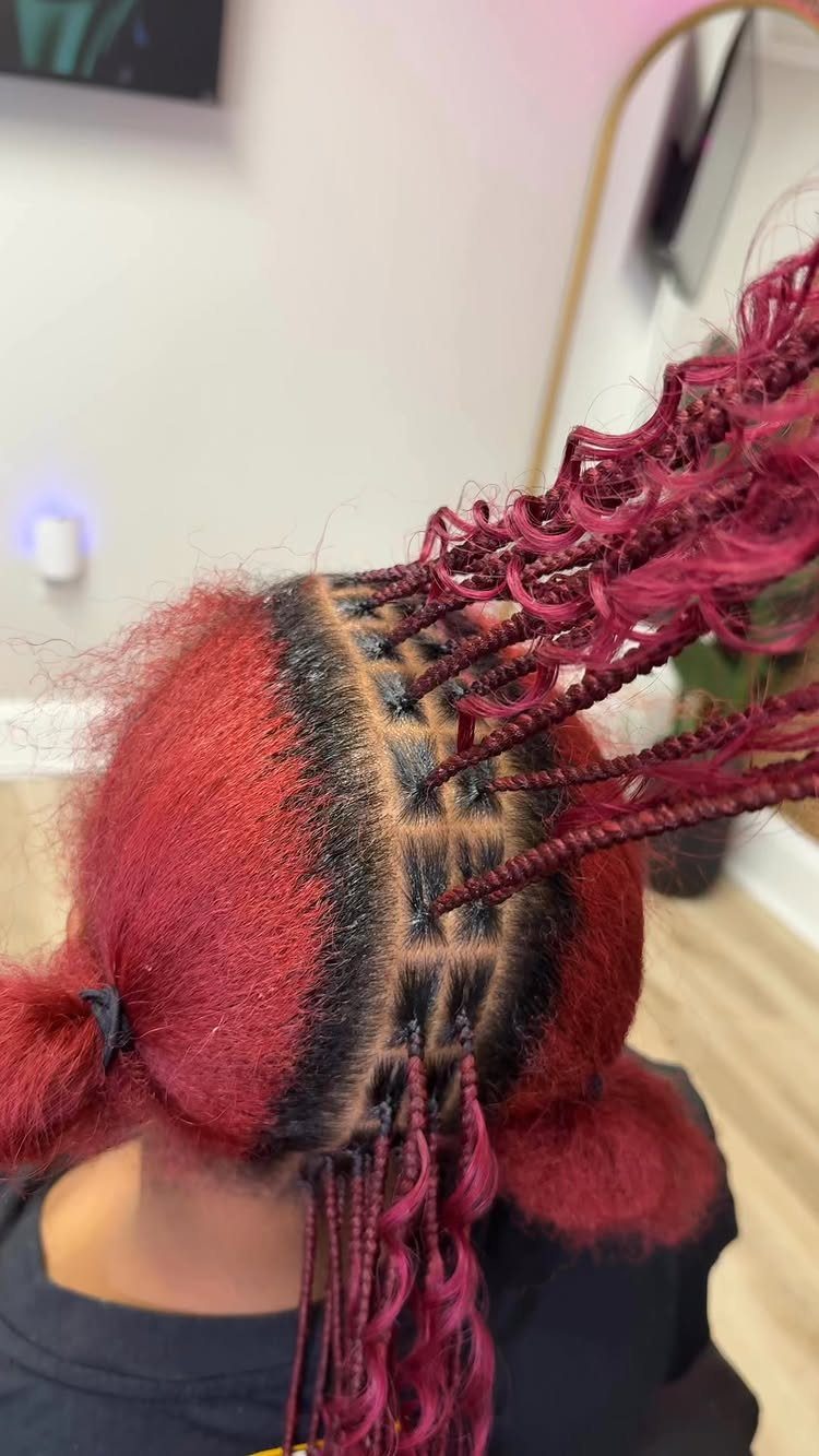 Red hair styled into burgundy twists over neatly sectioned square parts