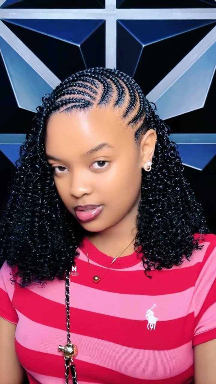 Woman displaying curved cornrows that transition into long, tight black curls