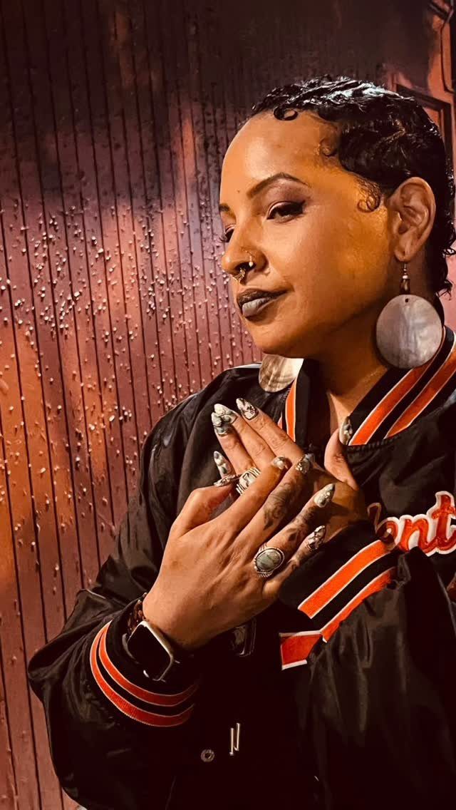 Short sculpted finger waves frame a person wearing large round earrings
