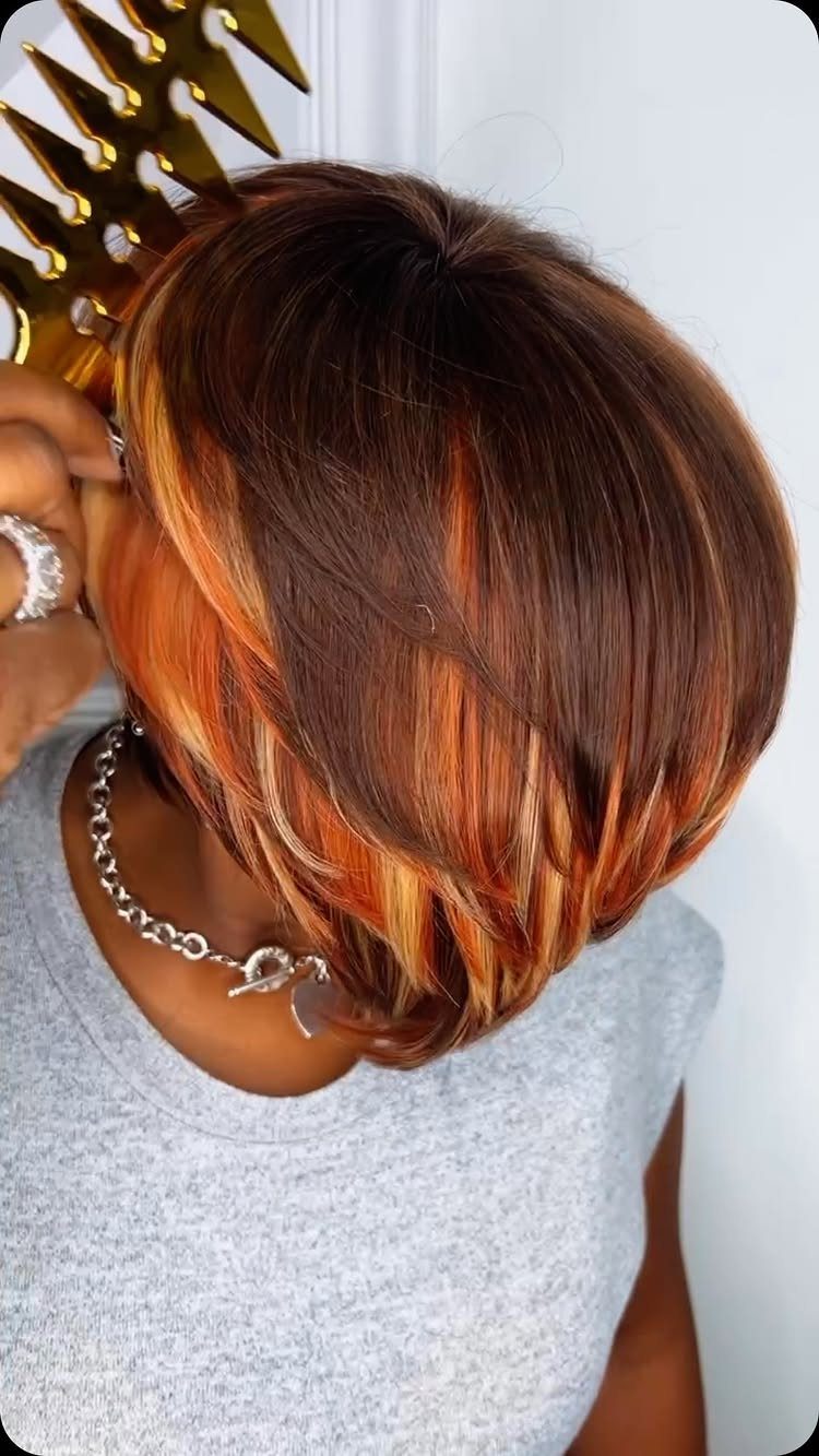 Short layered bob with copper-red highlights shown from above on a person