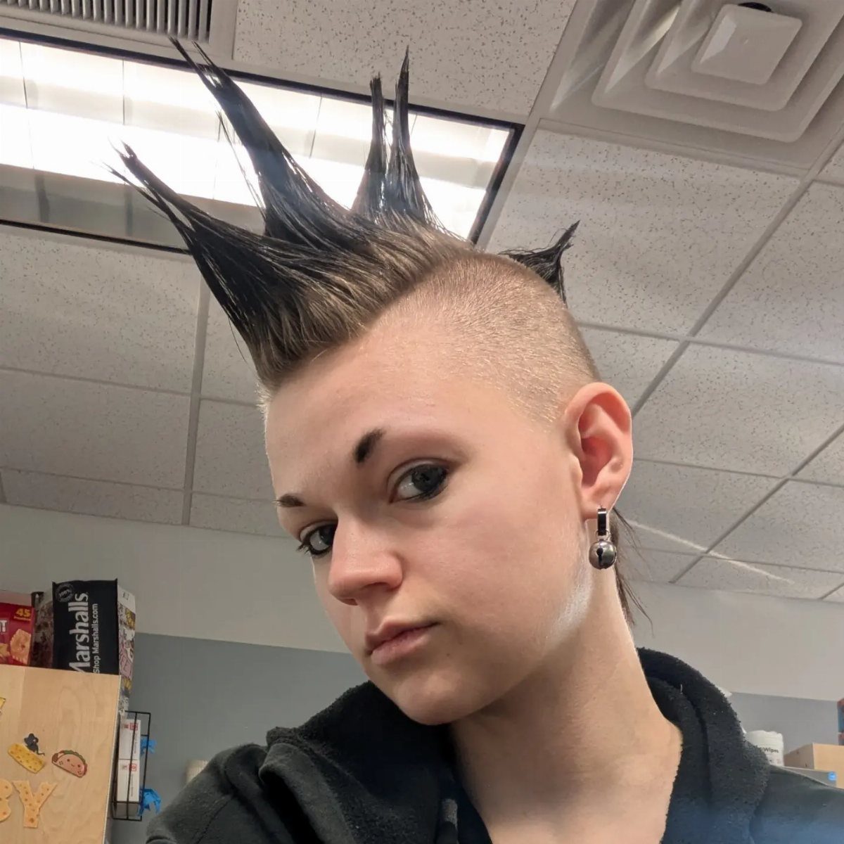 Person showing a spiked dark mohawk with closely shaved sides