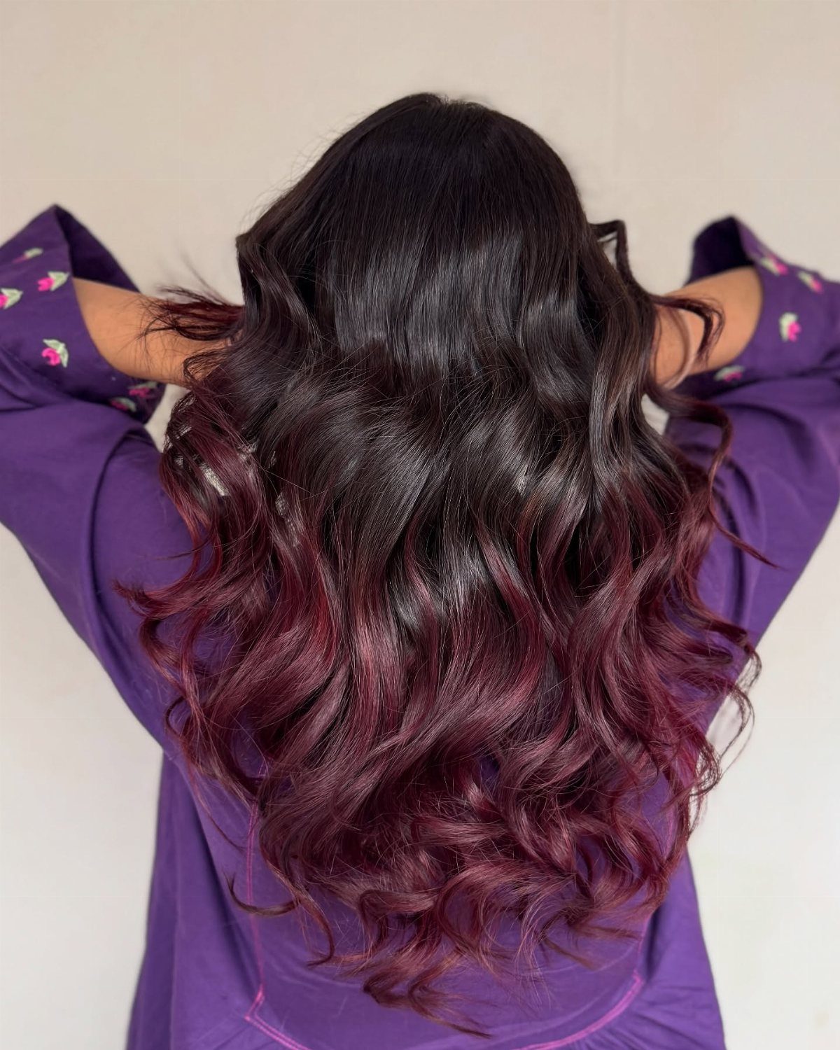 Wavy dark hair fades into vivid plum magenta ends