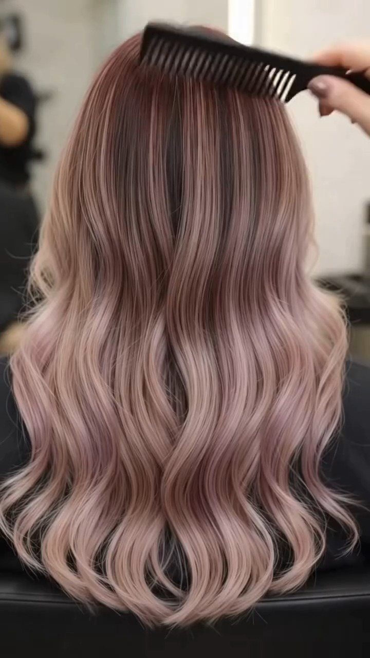 Wavy dusty rose hair with pale pink highlights combed at the salon