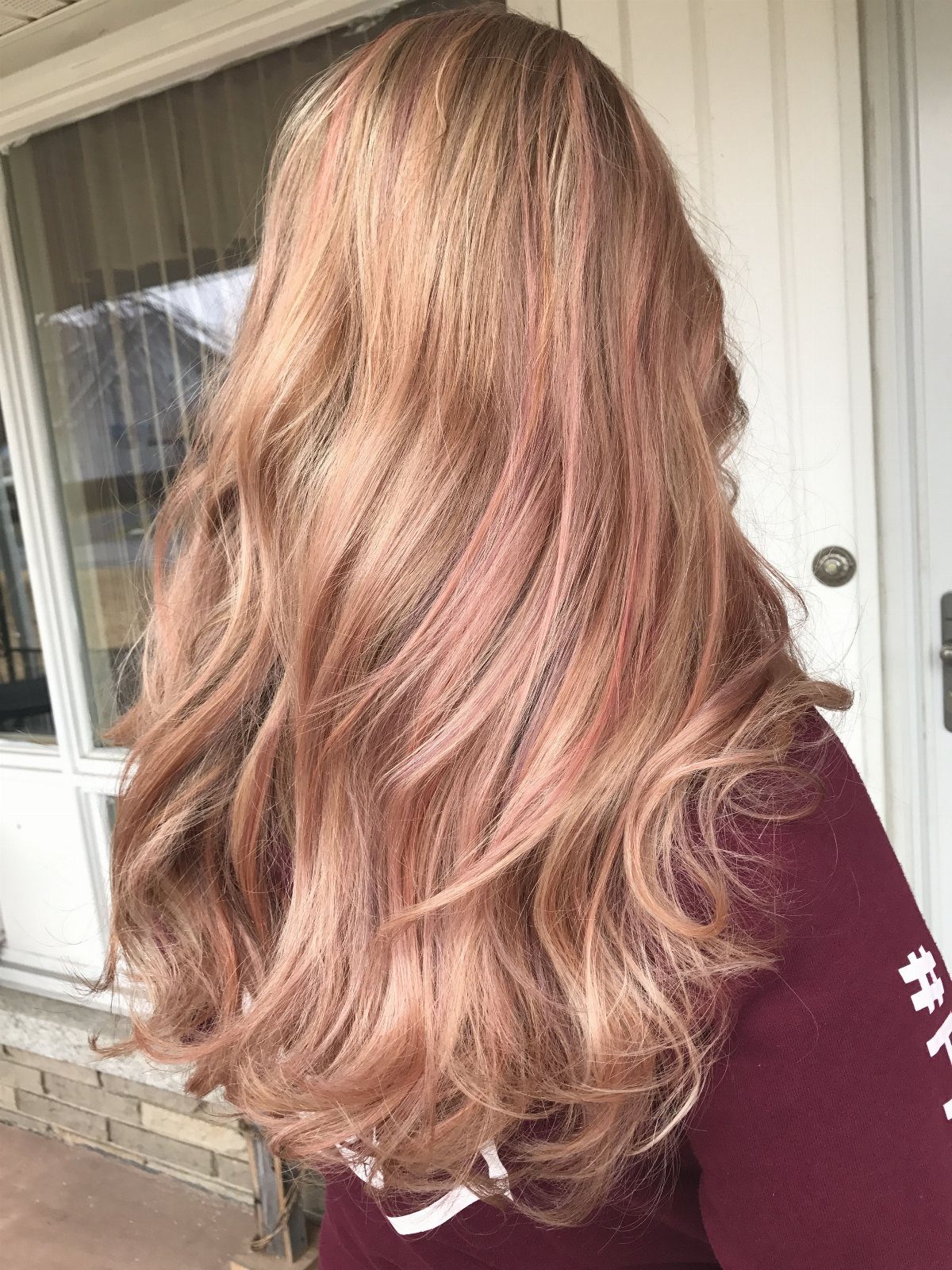 Long blonde hair with pink streaks flowing in loose waves