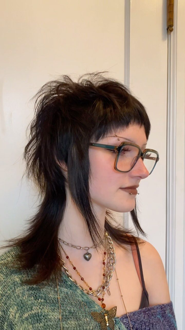 Dark short wolf cut with choppy bangs and long tapered back layers