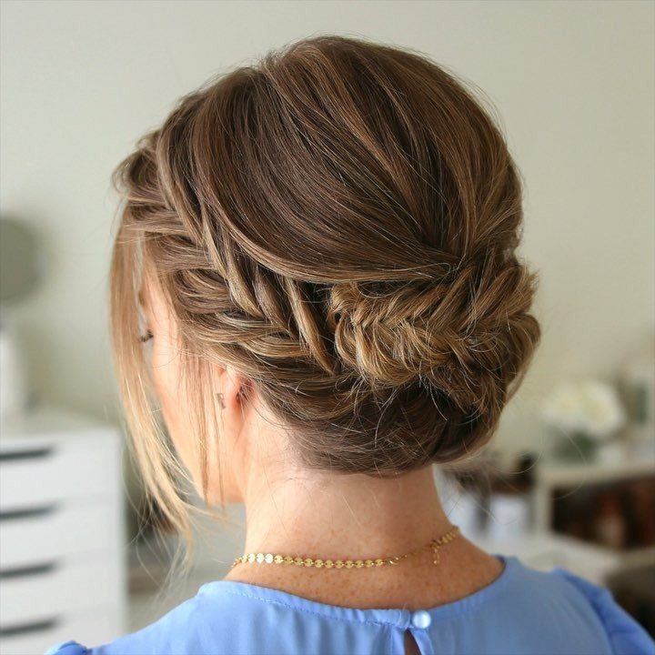 Braided brown short hair swept into a low updo with loose face-framing strands