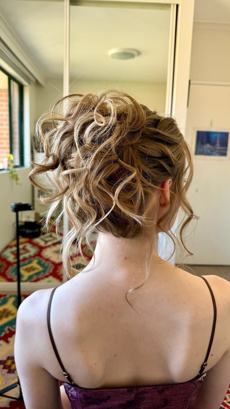 Short highlighted curls pinned up loosely at the back of a woman's head