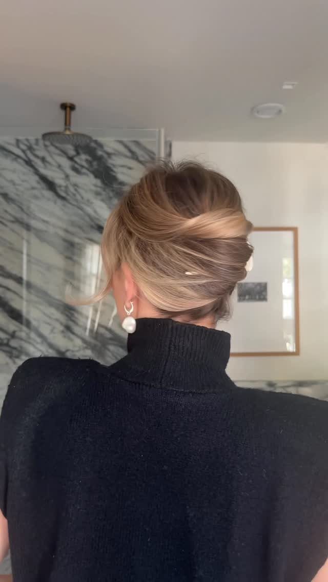 Woman with highlighted hair secured in a smooth French twist updo