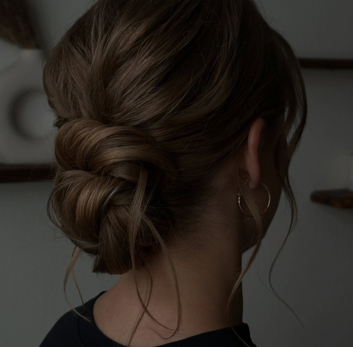 Loose brown chignon gathered at the nape with soft tendrils