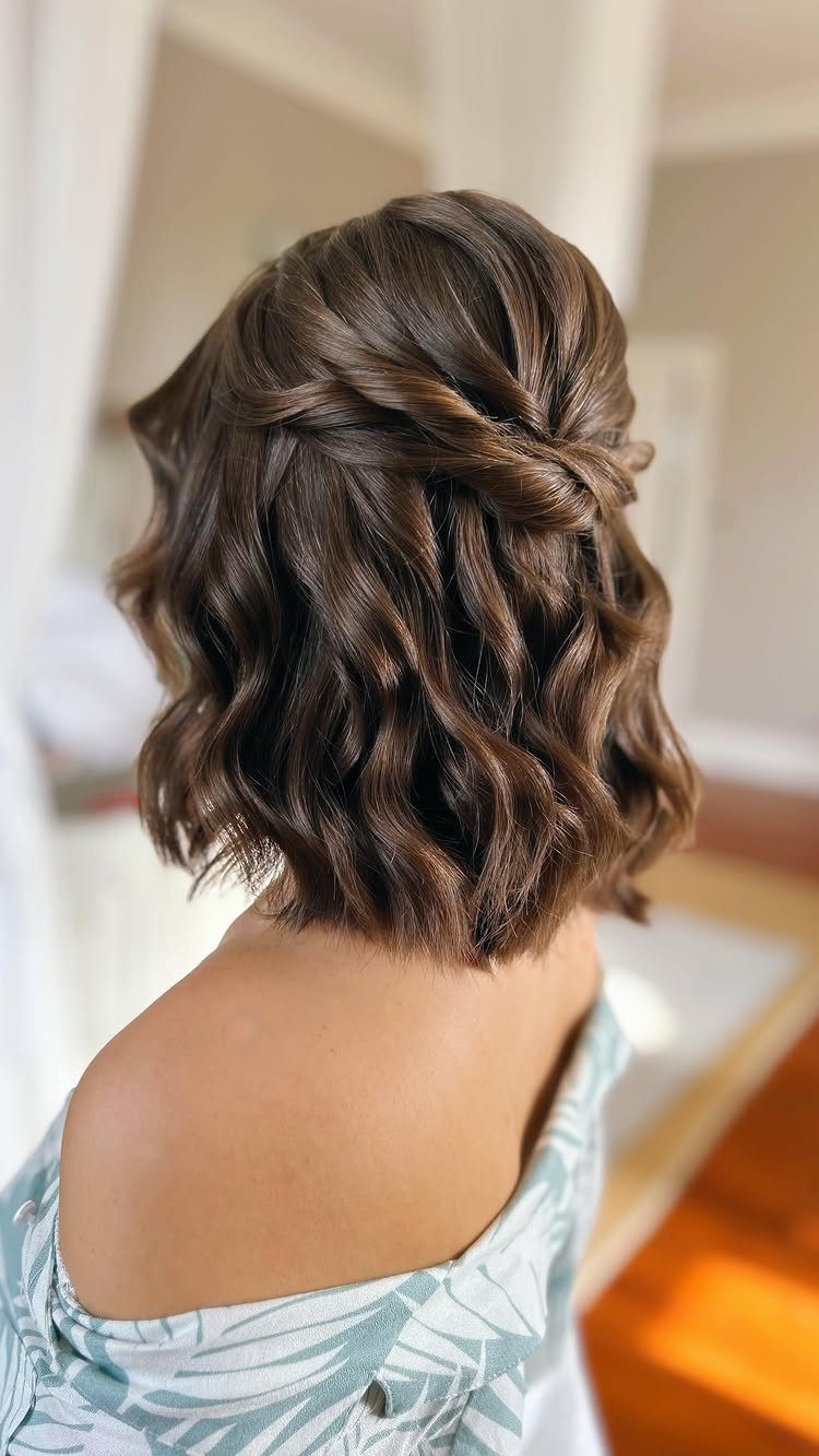 Loose pinned waves swept into a twist at the back of dark hair