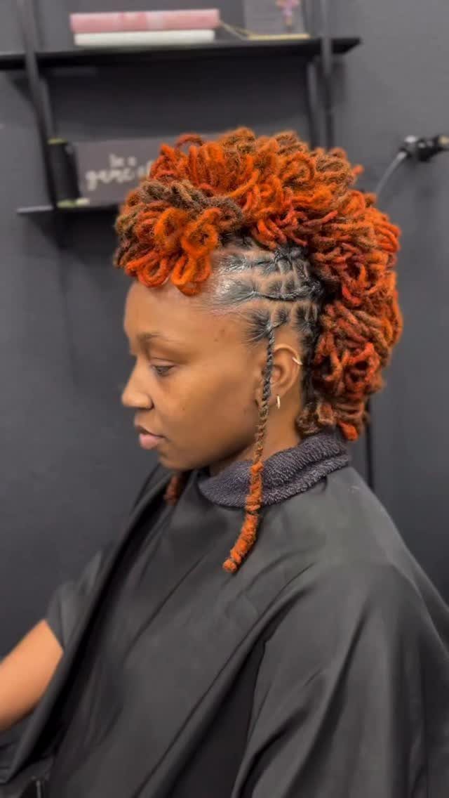 Woman with orange twisted locs styled into a short-hair updo at a salon