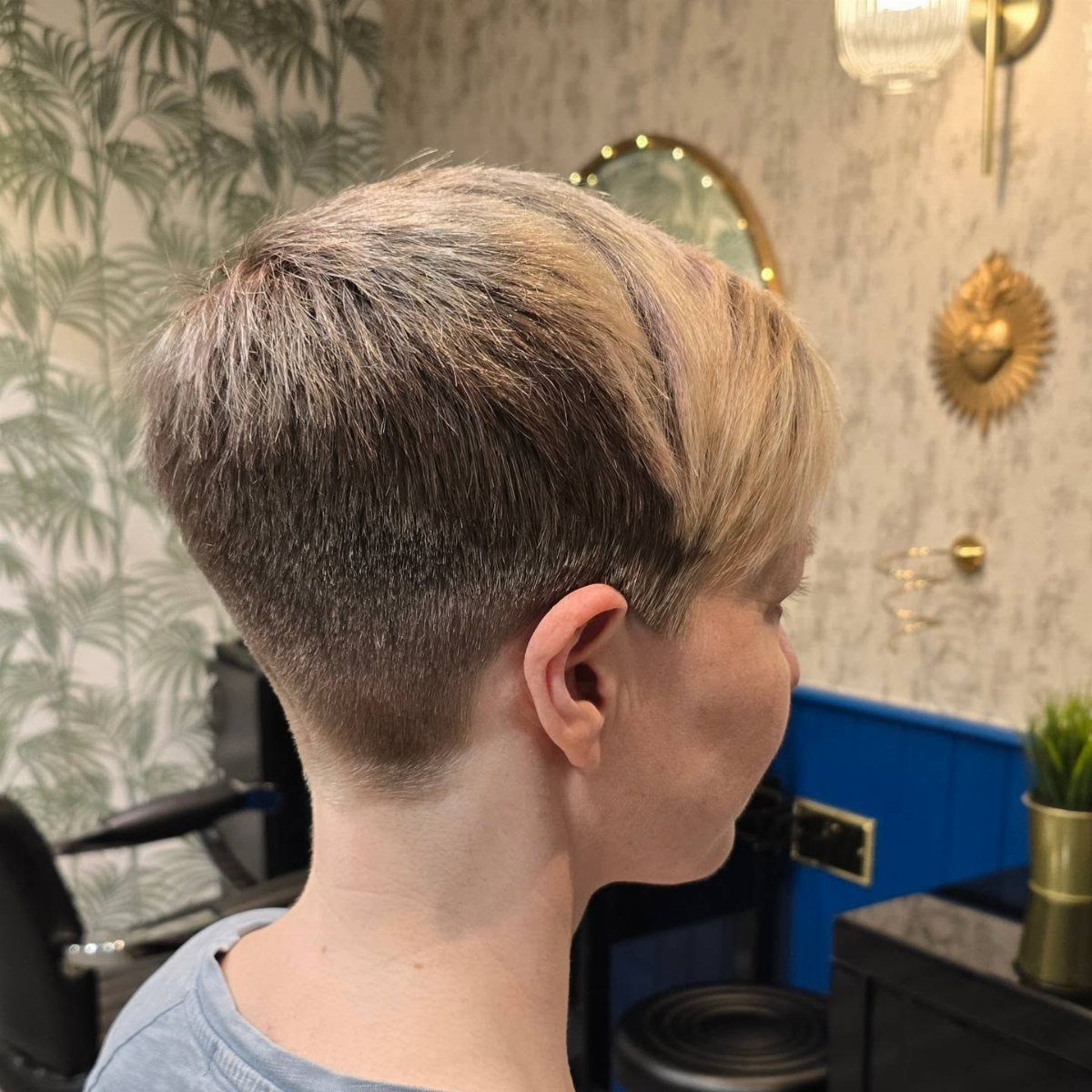 Person showing a textured pixie cut with closely cropped sides and longer top