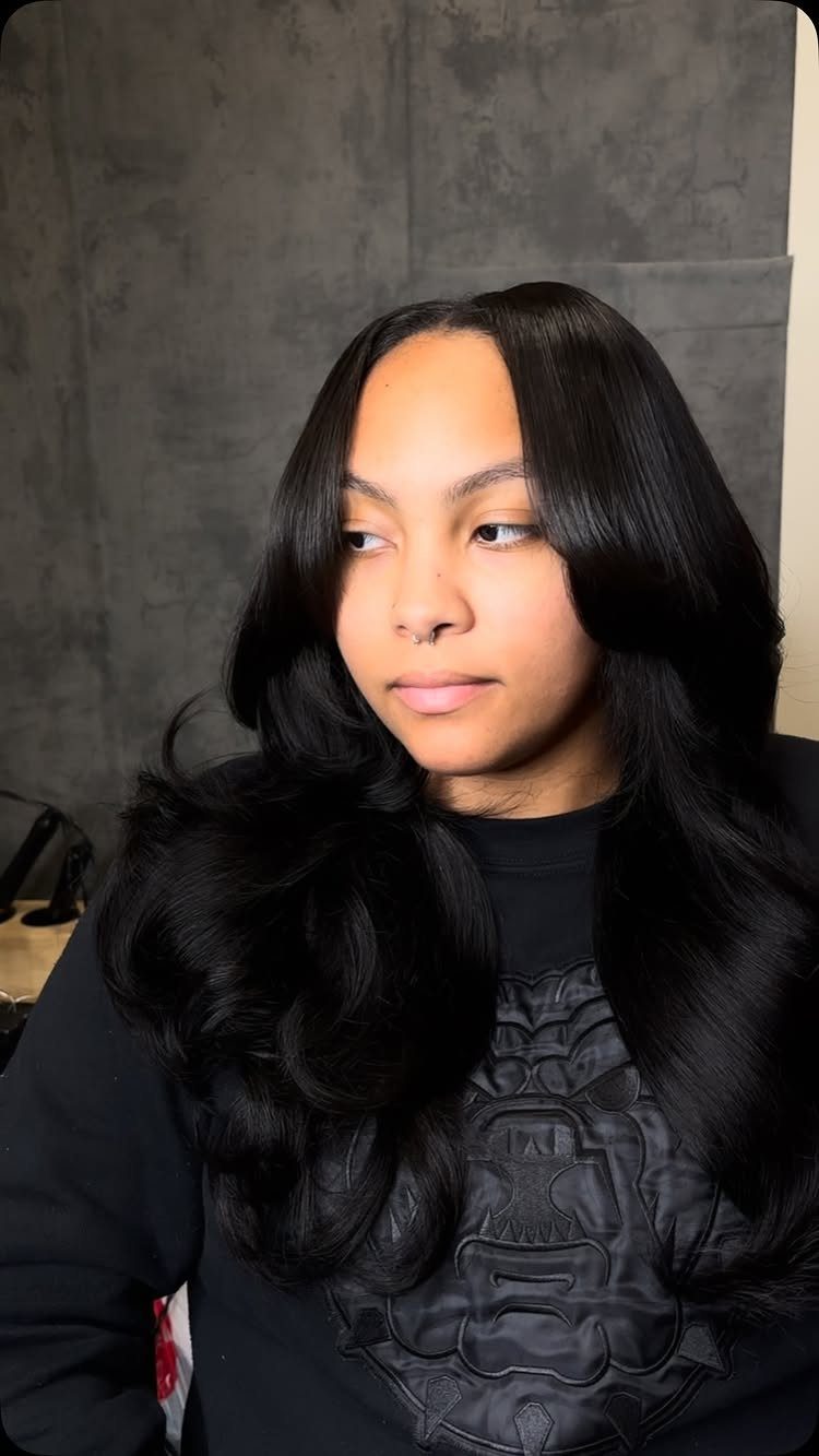 Glossy black middle-parted hair styled in long, voluminous waves