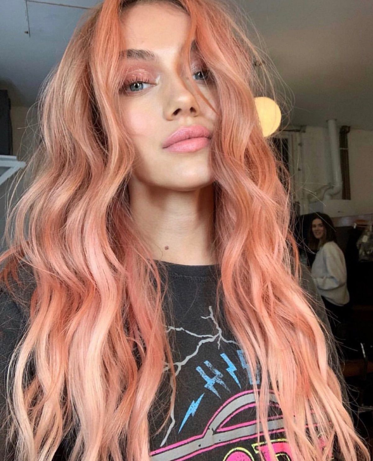 Person with a middle part and long, wavy pastel pink hair