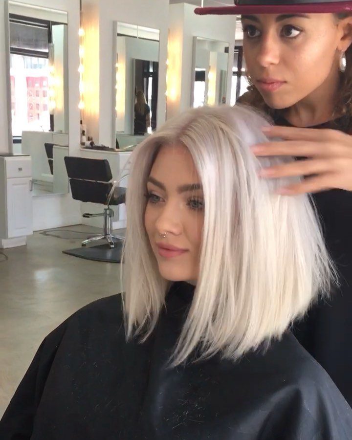 Blonde woman with a center-parted bob having her hair styled in a salon