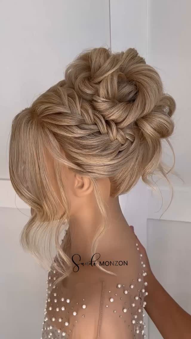 Blonde woman showing an intricate braided updo with loose face-framing strands