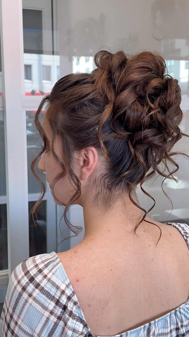 Brown medium hair styled in a curled updo with loose tendrils