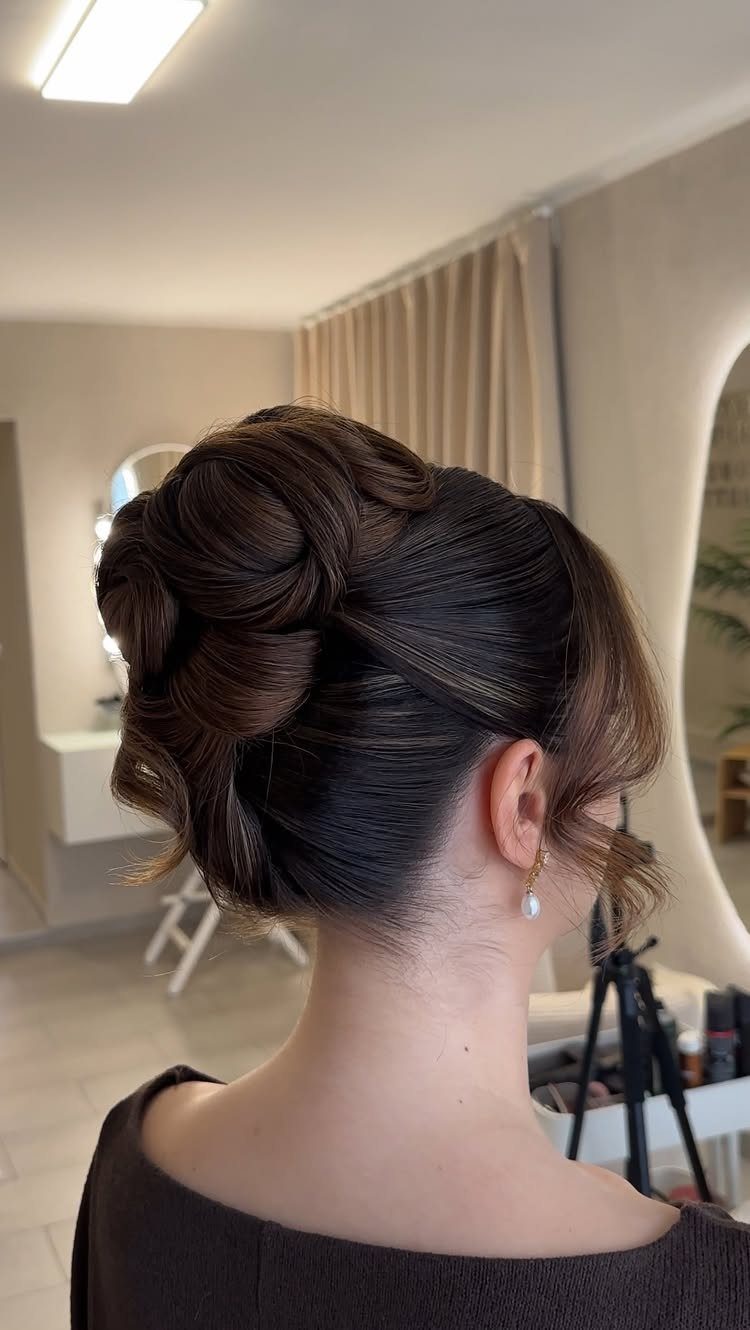 Dark brown medium hair arranged in a polished updo with curled tendrils