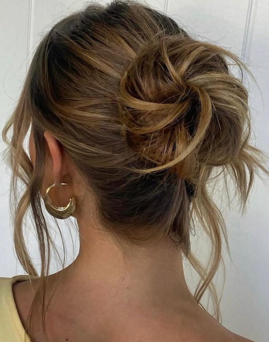 Loose brown messy bun with escaped strands viewed from behind