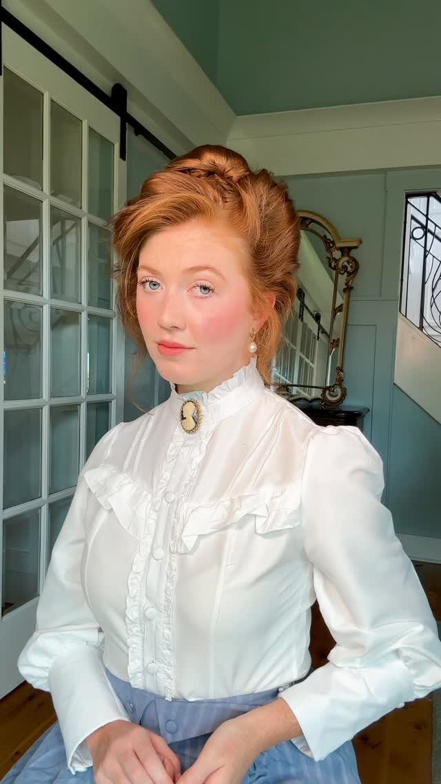 Red-haired woman posing with her hair pinned up in a neat style