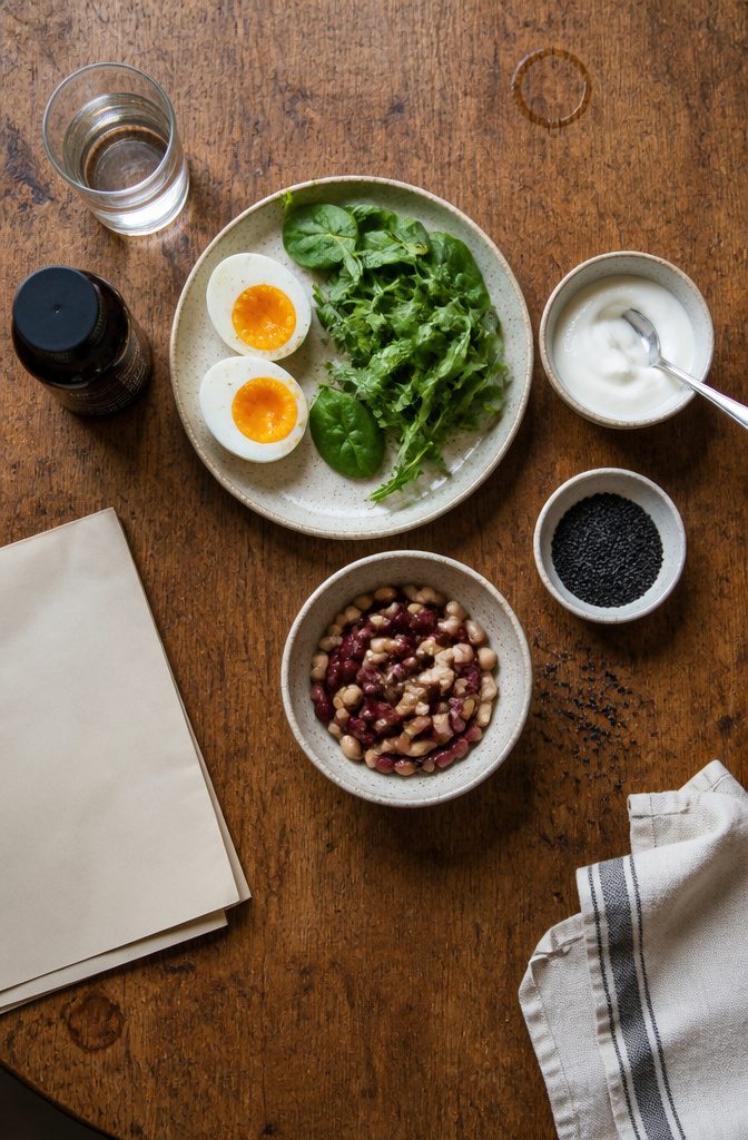 Healthy meal with eggs greens beans yogurt and whole grain bread